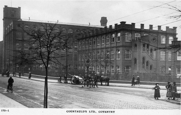 A large factory in the early 20th Century, with horse-drawn carts outside it.